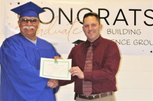 A graduate is given a certificate for a rehabilitation program at a California prison.