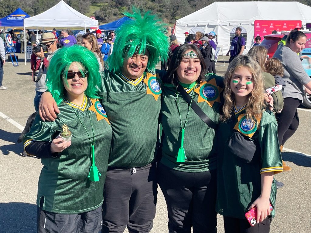 Polar Plunge with four people wearing green outfits and CDCR logos.