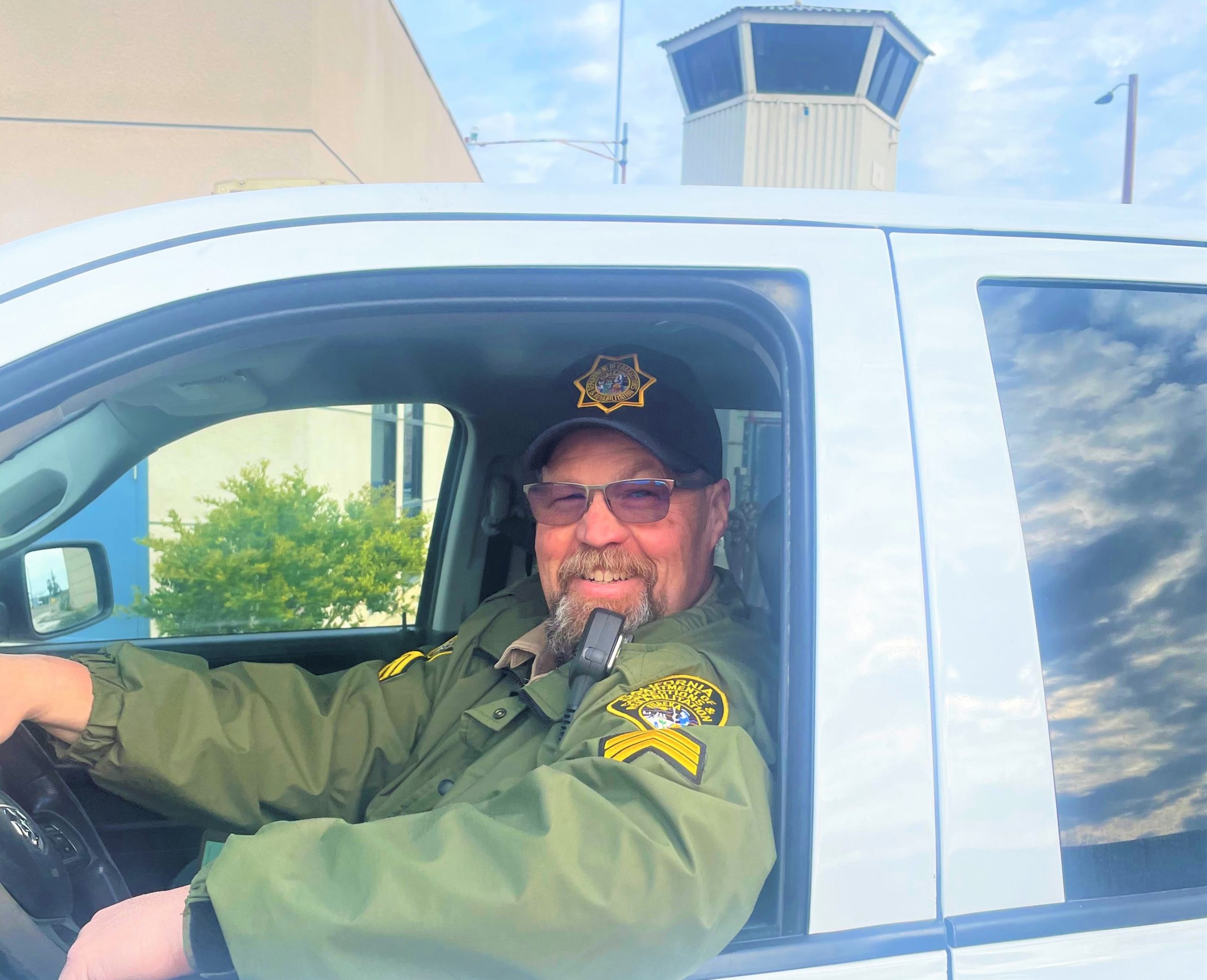 Sergeant Jonathan Haynes sits in a CDCR vehicle, smiling, as he prepares to retire from his 30-year career.
