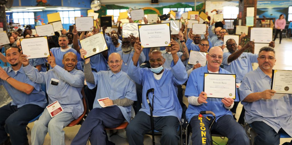 Men holding up certificates of completion and job certifications from CALPIA at CSP-Solano.