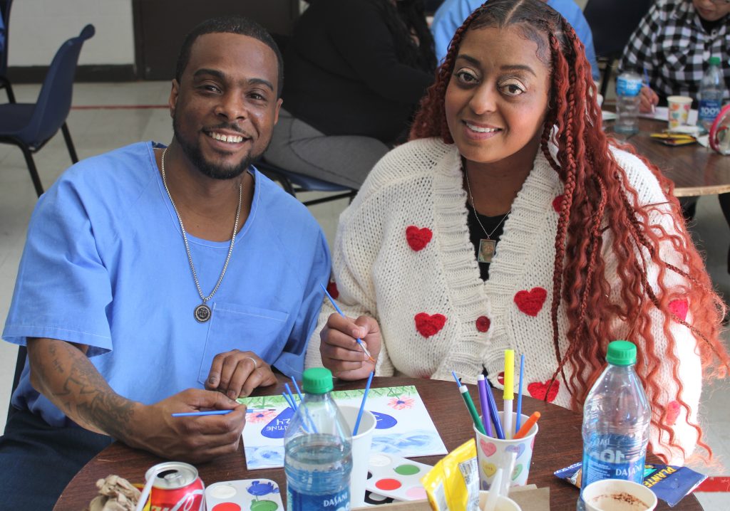 Valentine's Day visiting at Centinela State Prison with an incarcerated person and a woman wearing a heart-decorated sweater.