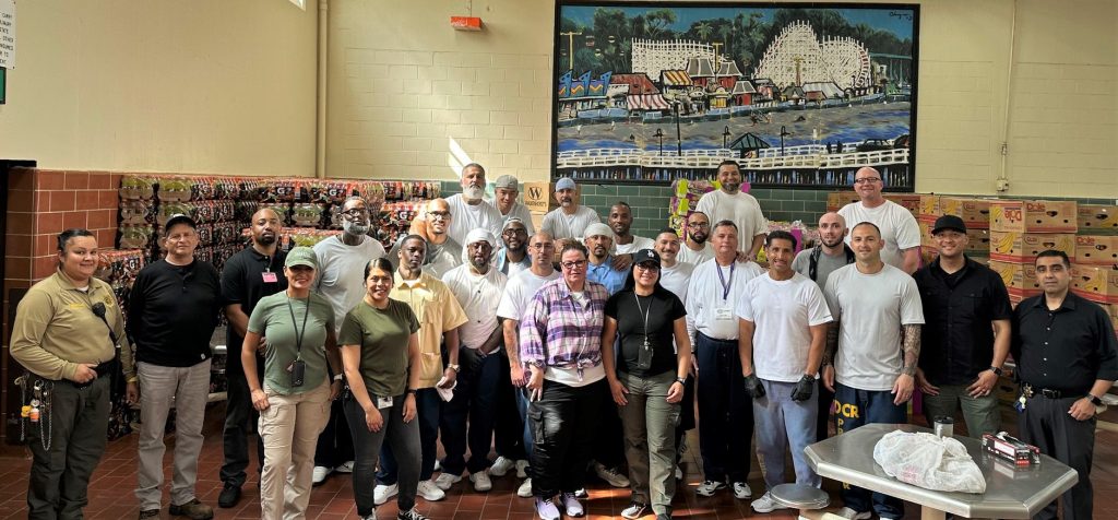 Incarcerated people and prison staff at gather for a group photo.