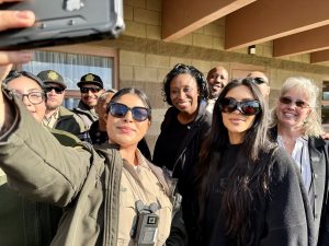 A group of CDCR staff pose for a photo with Kim Kardashian as she tours a prison.
