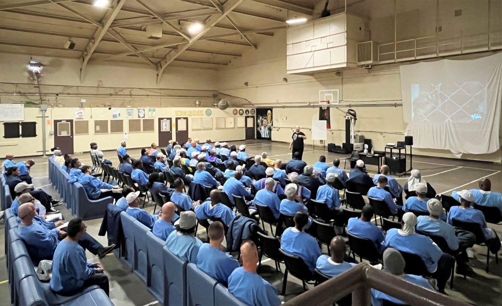 Incarcerated people sit in a training session.