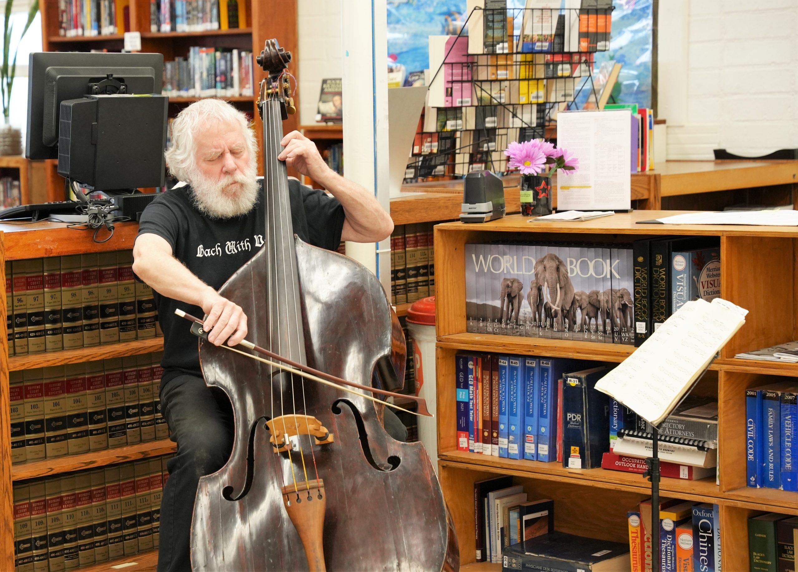 A man plays an antique bass during the Bach with Verse concert at California Institution for Women.