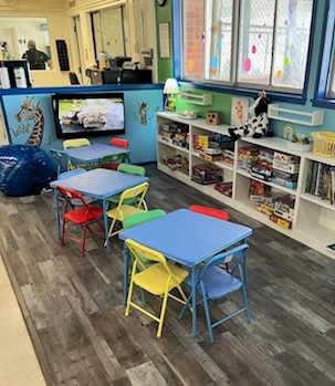 CIW library for children with tables, chairs, activities, and books.
