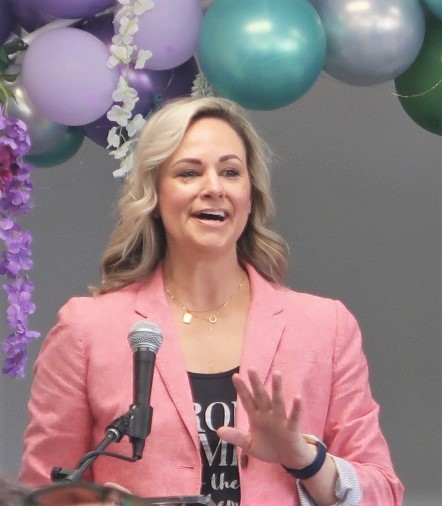 A woman wearing a pink jacket speaks at the Pelican Bay State Prison first International Women's Day event.