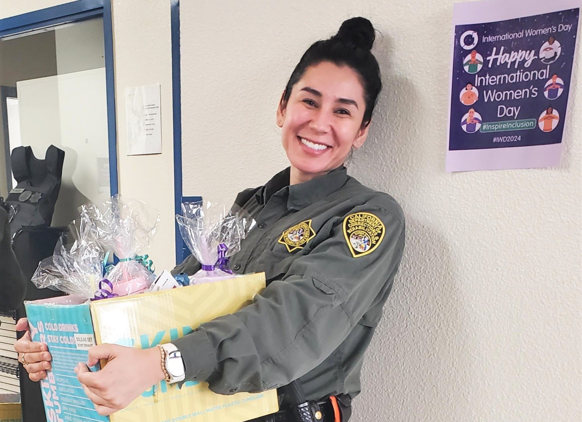 Woman carries a box of gift bags for the Pelican Bay State Prison International Women's Day event.