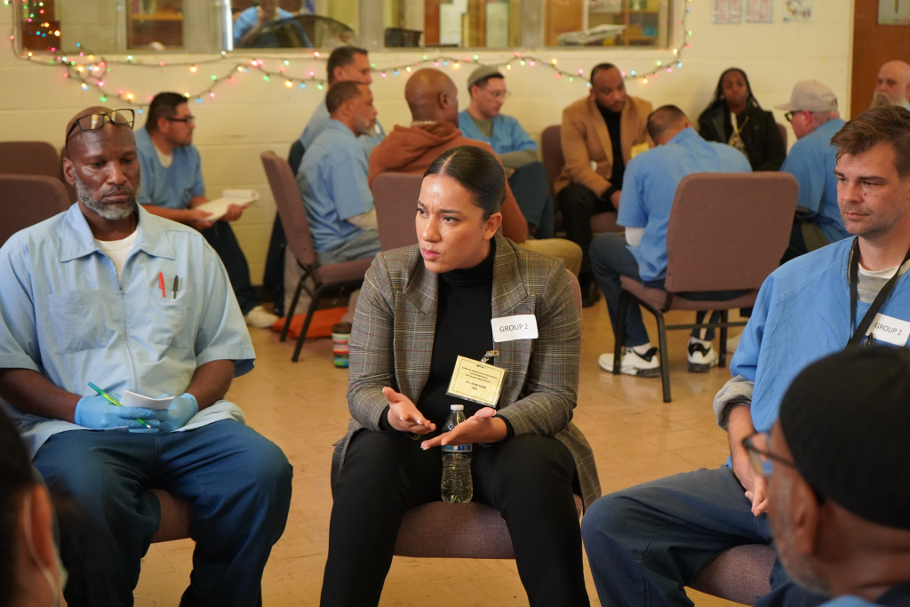 Jenkins staff speaking with incarcerated at forum inside San Quentin Rehabilitation Center.