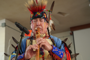 Natie AMerican man playing song at Powwow