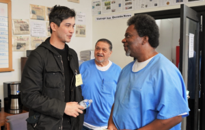 An attorney speaks with two incarcerated people at San Quentin.