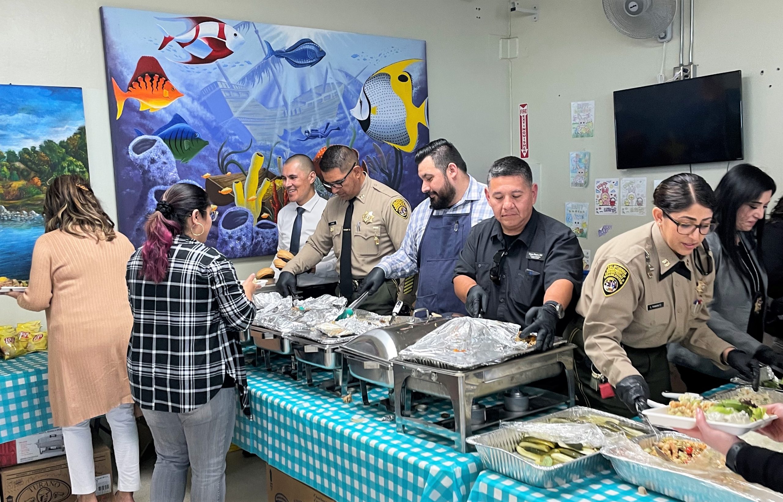 Managers and leaders serve food to administrative professionals at Calipatria State Prison.