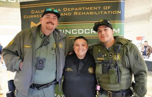 A staff wellness fair with three people in front of a CDCR banner at CCWF.