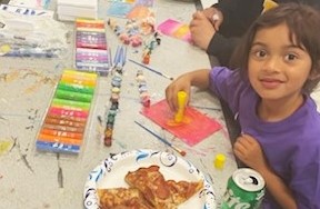 A child draws at a table at CIW as part of the Get on the Bus program.