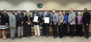 CMF bike project honored at school board meeting with prison staff and school officials in a group photo.
