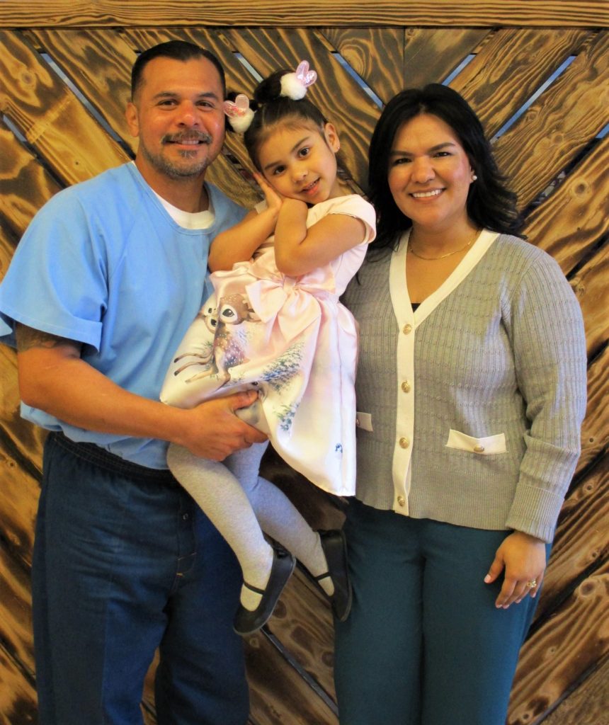 An incarcerated person, a woman, and a child pose for an Easter photo.
