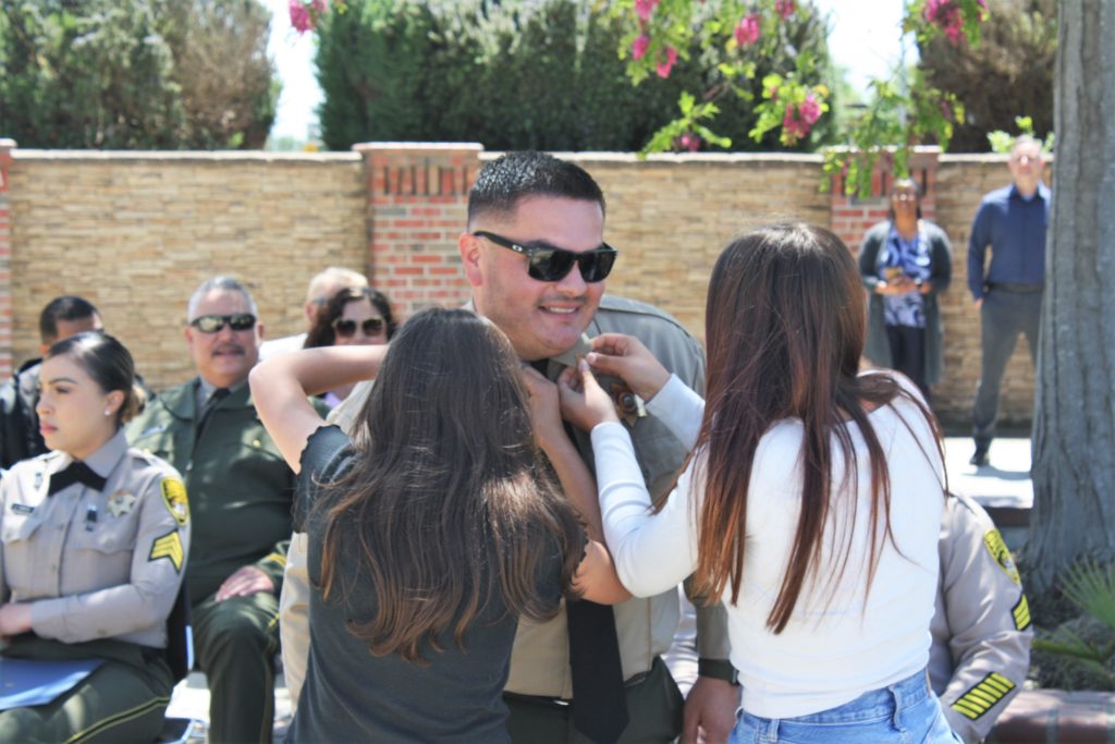 CTF ceremony with two family members pinning rank to a new sergeant's collar.