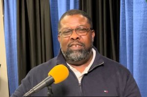 Victim Offender Dialogue manager Robert Love sitting with a microphone.