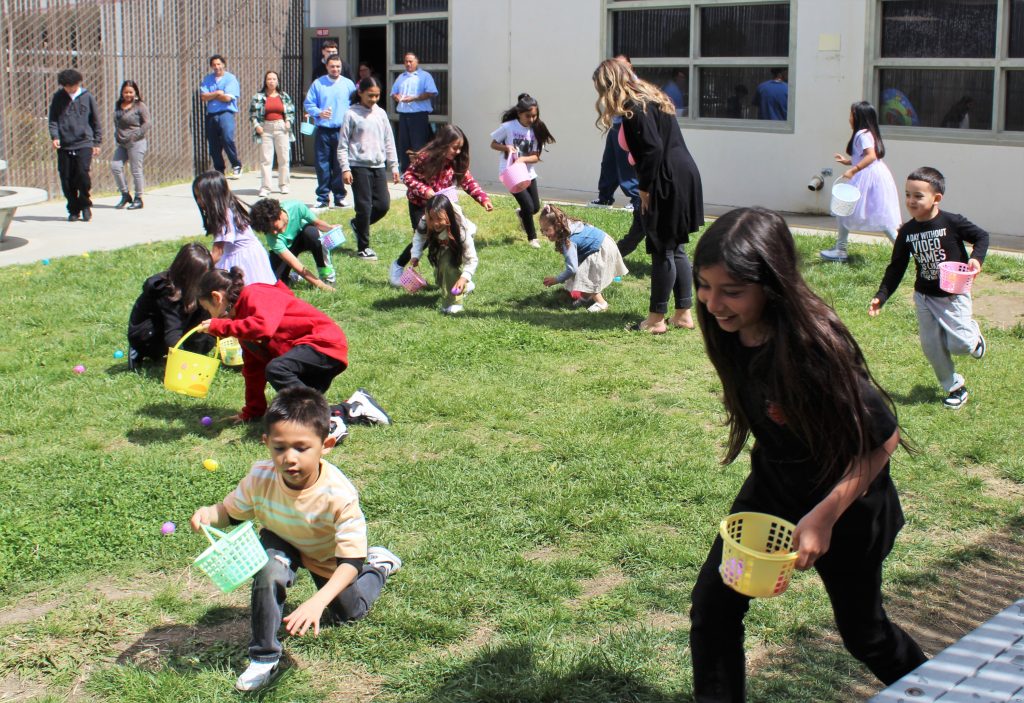 Children hunt eggs in a prison visiting yard at Pleasant Valley.