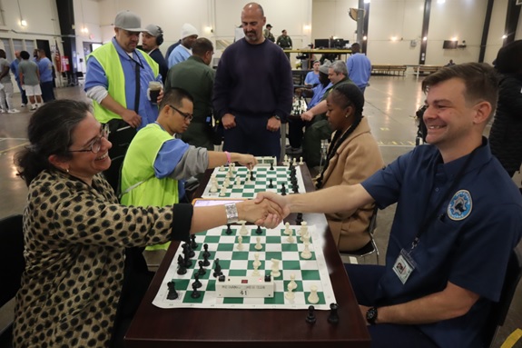 San Quentin chess game with two people, one of them incarcerated, shaking hands over the game board.