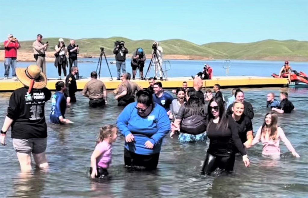 Staff in water in a lake for Polar Plunge.