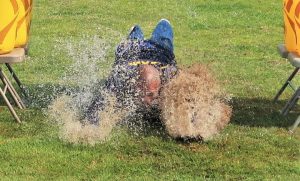 VSP Special Olympics Polar Plunge event with an incarcerated person sliding through wet grass.