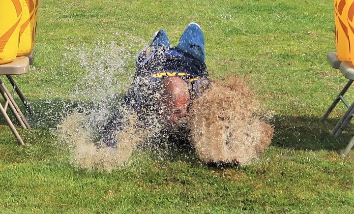 VSP Special Olympics Polar Plunge event with an incarcerated person sliding through wet grass.