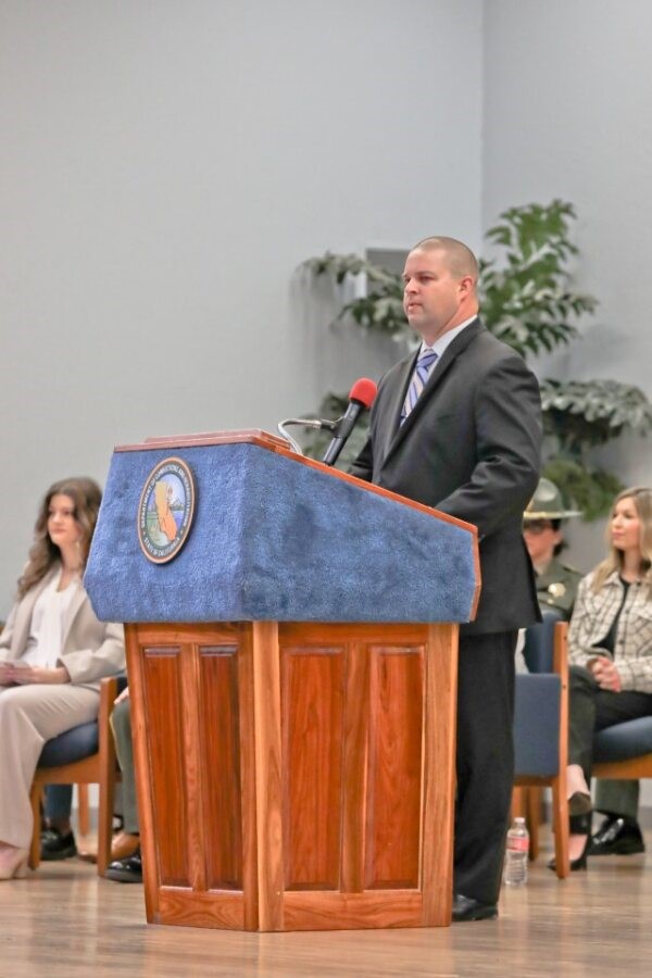 A warden speaks at a lectern. 