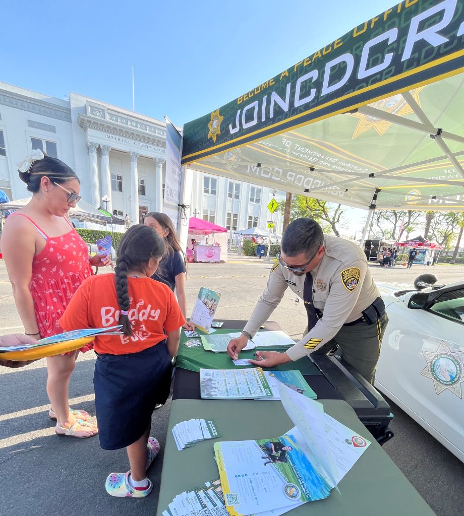 A Calipatria recruiter stamps a card for a young person at Law Day.