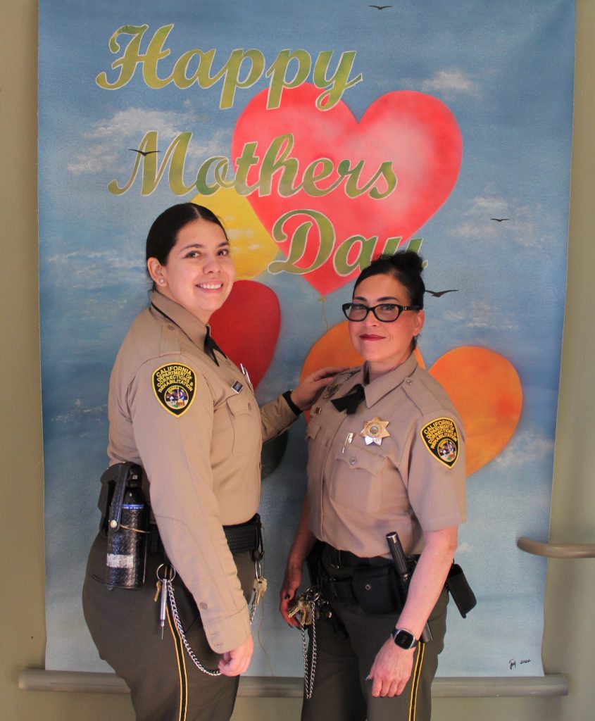 Visiting staff with a happy Mother's Day backdrop.