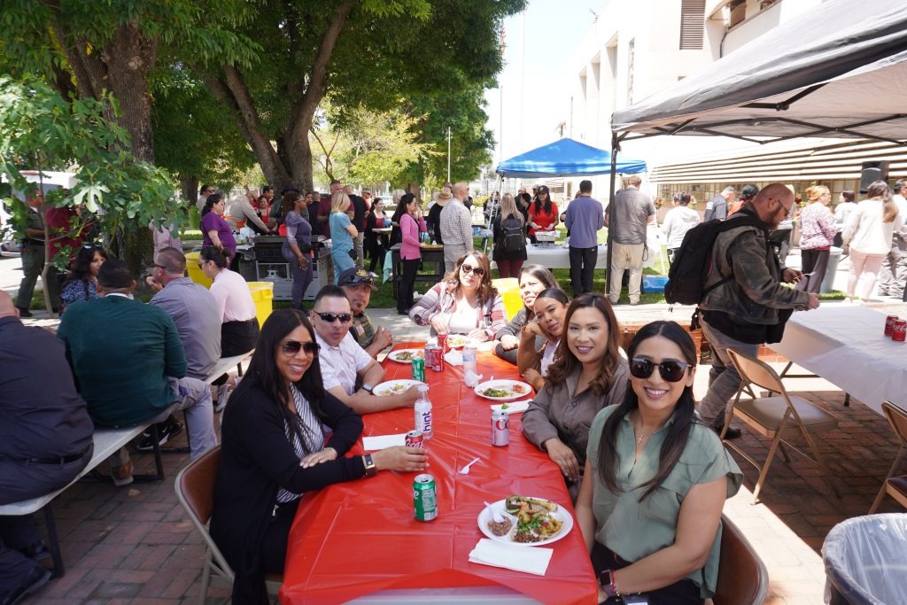 People sitting at a table outside at California Institution for Men in Chino.