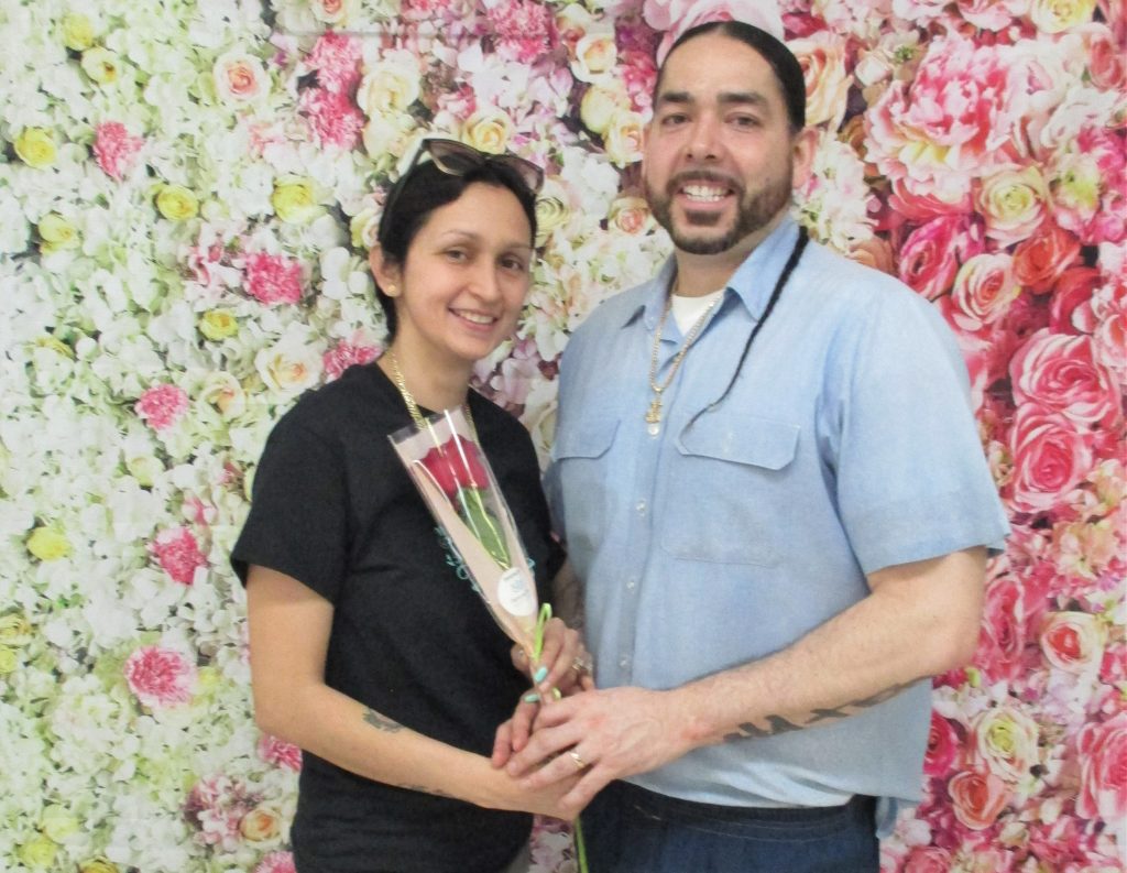 An incarcerated man at CMF gives a rose to a woman during visiting on Mother's Day.