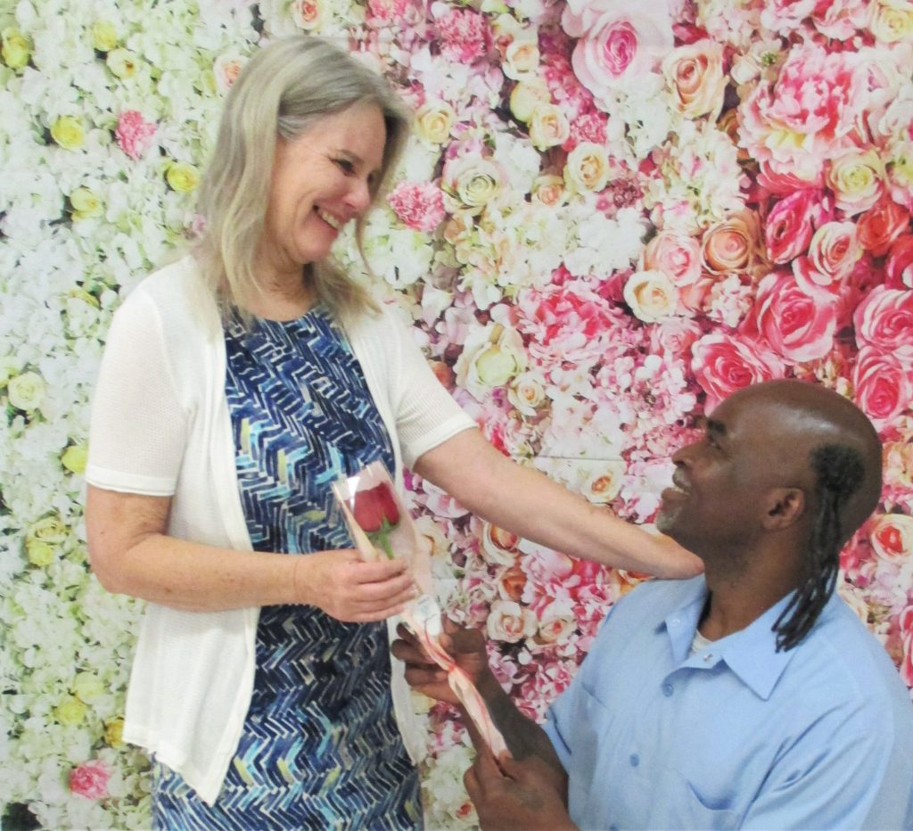 CDCR visiting with an incarcerated person presenting a rose to a visiting loved on during Mother's Day.