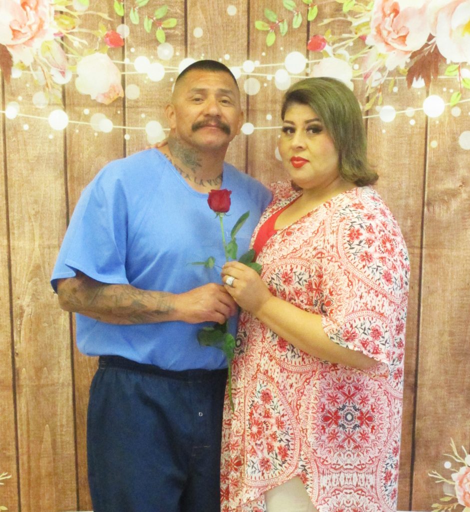 A man and woman holding a rose.