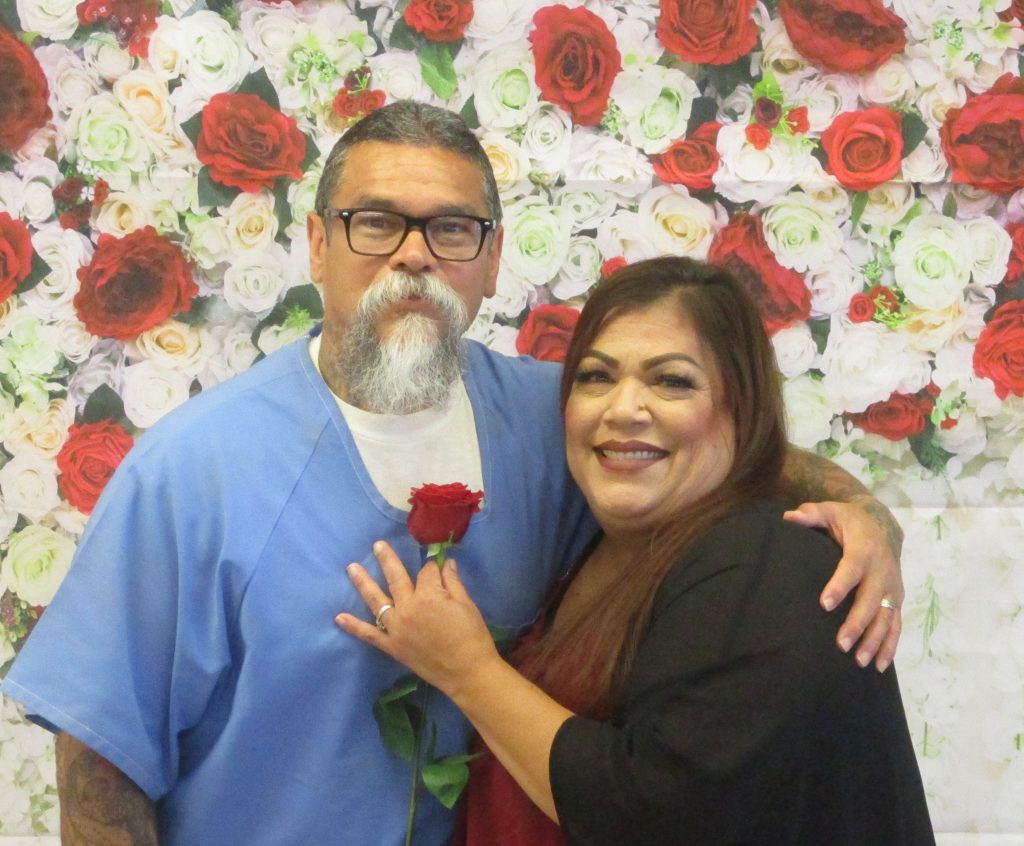 A couple with the woman holding a rose during prison visiting.