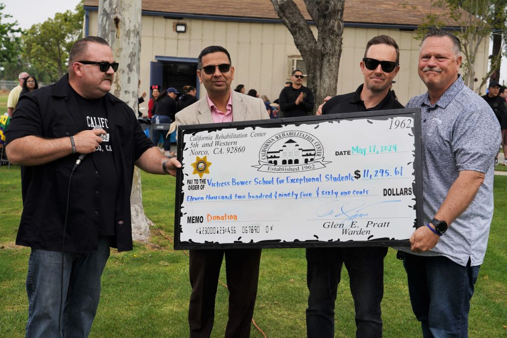 Staff from California Rehabilitation Center present an over-sized check to a special-needs school. 