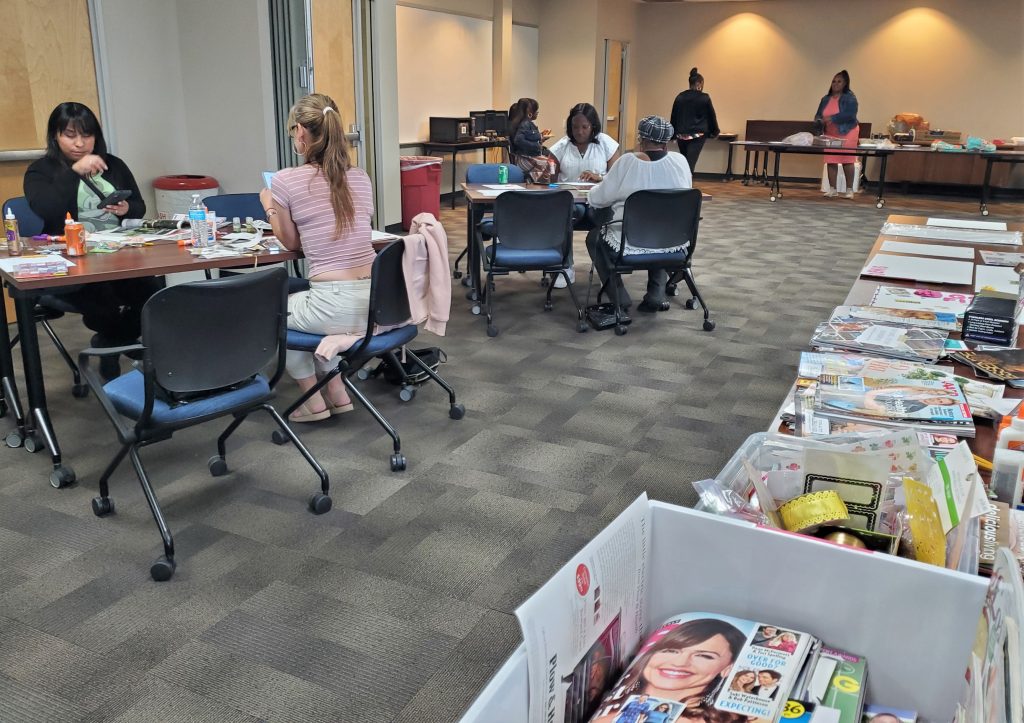Women create vision boards during a Mother's Day themed meeting at a parole office.