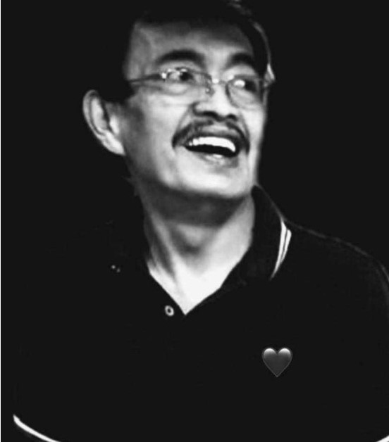 Guillermo Giron smiling and looking to the side.