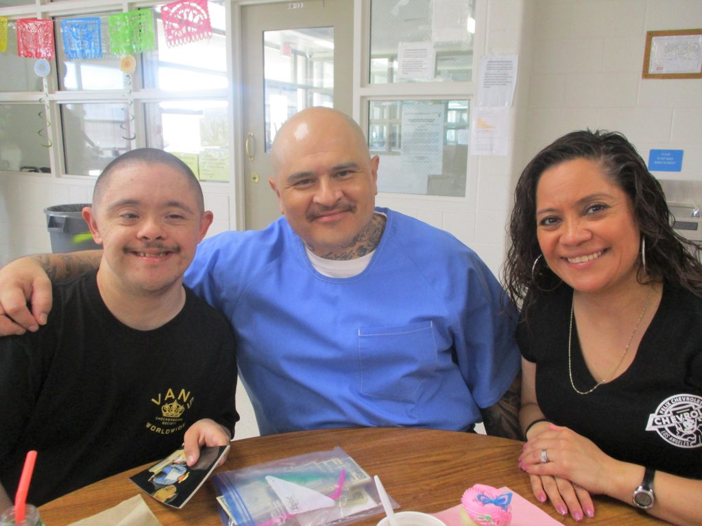 A man, woman and a child visit in a prison.