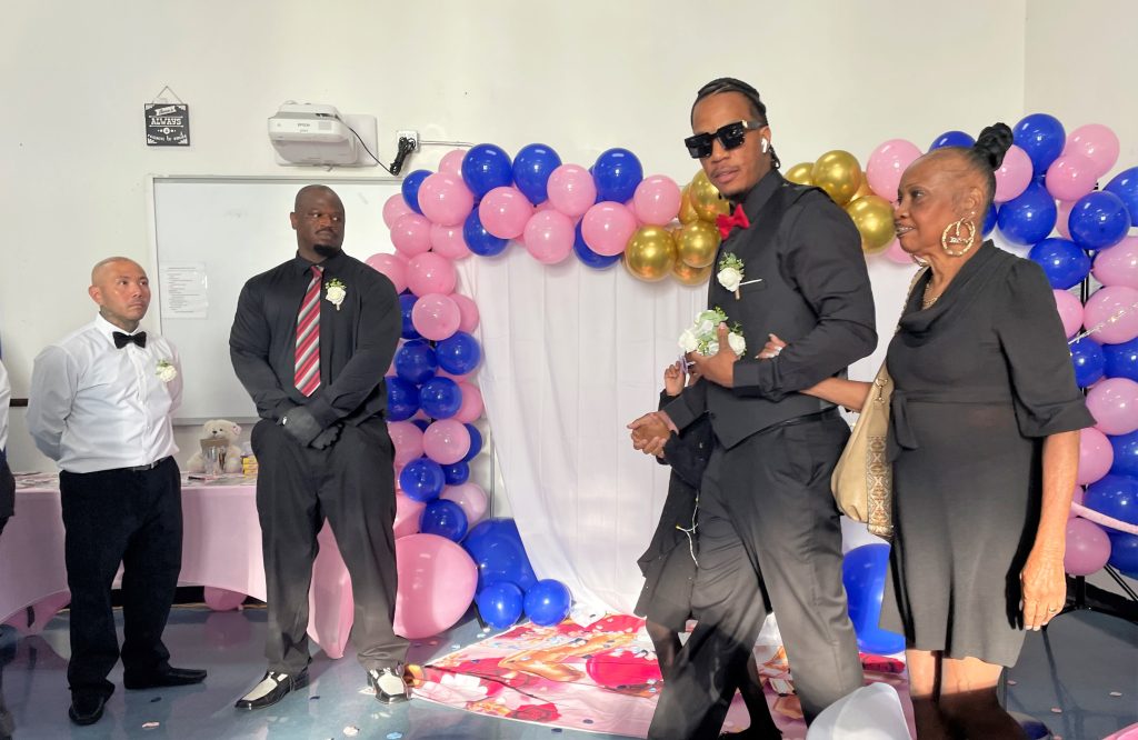 A young man walks into the male community reentry program father daughter dance in Long Beach.