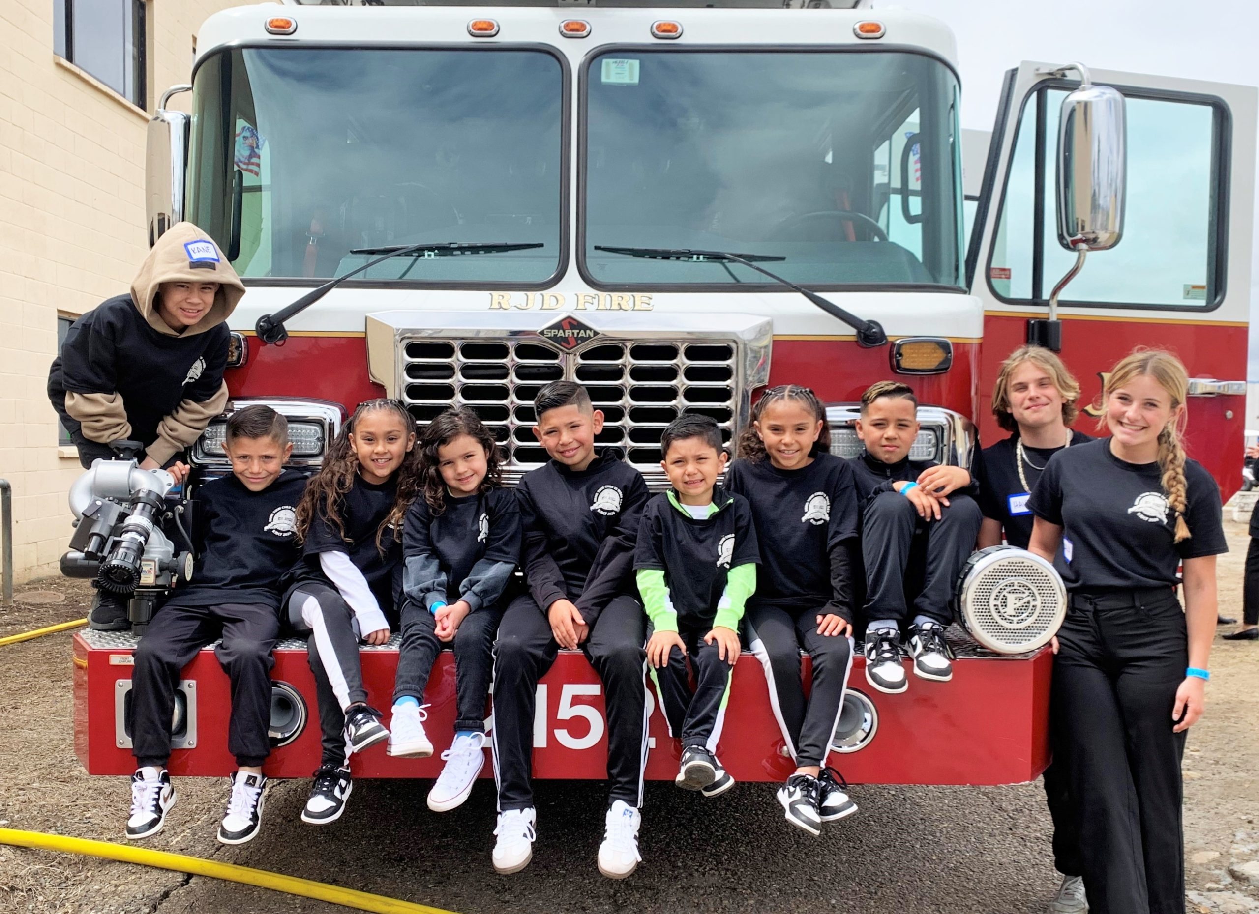 Take Your Child to Work Day with children sitting on a front bumper of a prison fire engine.