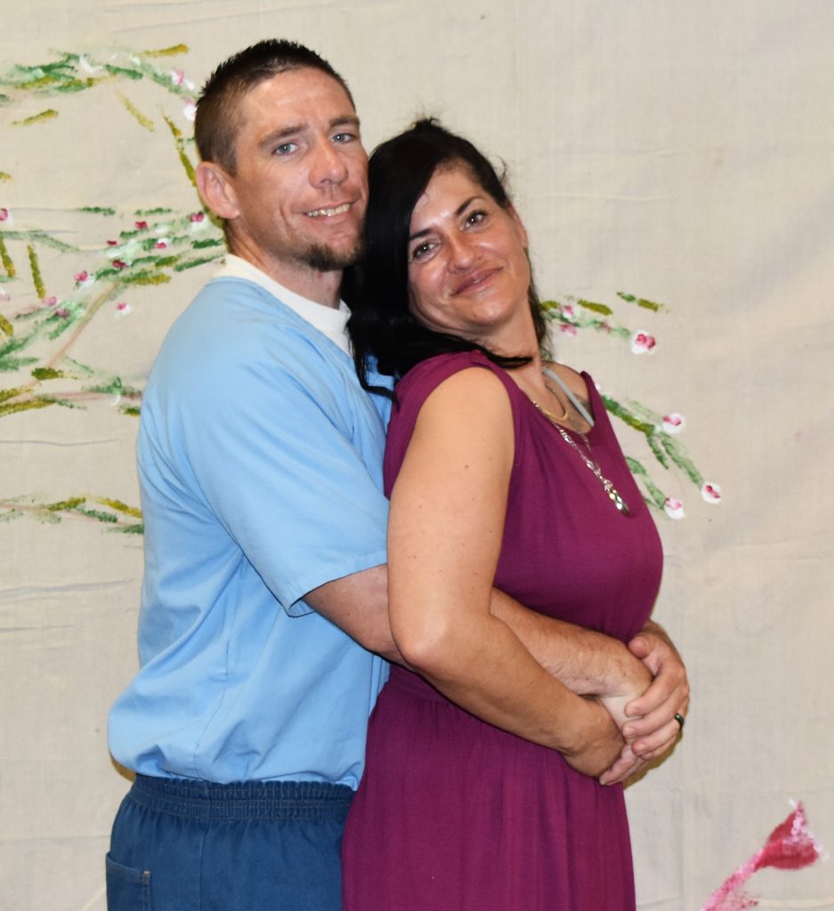 A woman is held by her incarcerated loved one at Sierra Conservation Center during a visiting event.