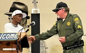 A sergeant shakes hands with an incarcerated person after receiving an award.