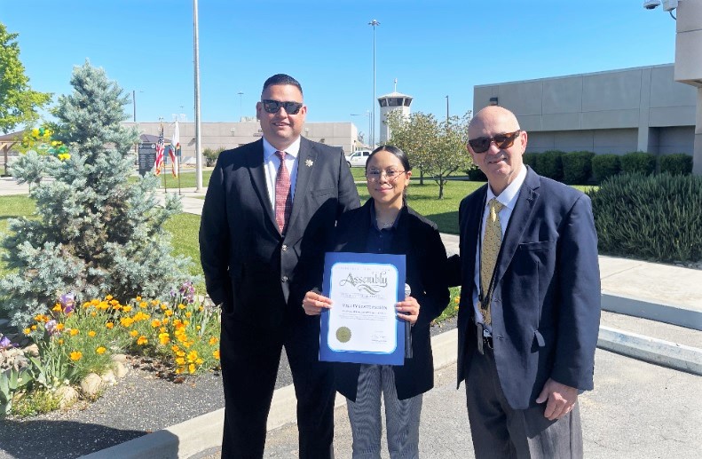 Prison warden and chief executive officer with a representative from an elected official's office.