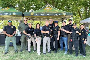 Recruiters standing at a booth in a park.