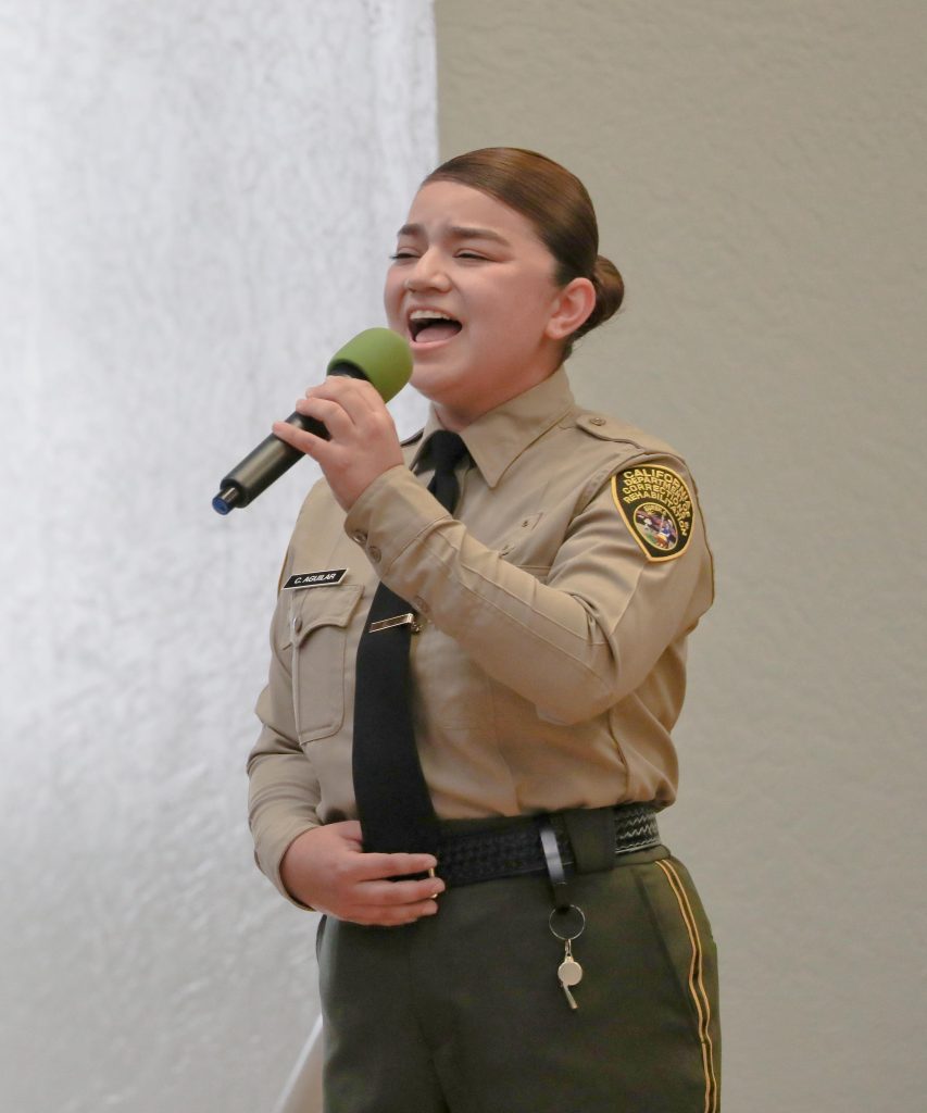 A cadet sings the national anthem at the academy graduation.