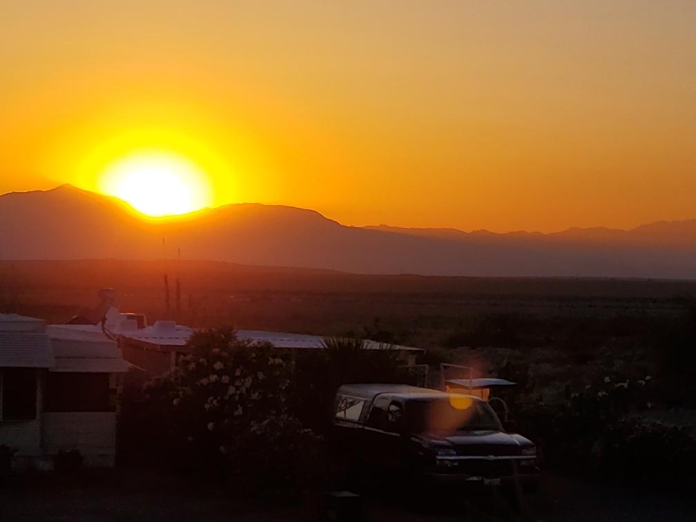 Sunset over recreational vehicles in the desert.