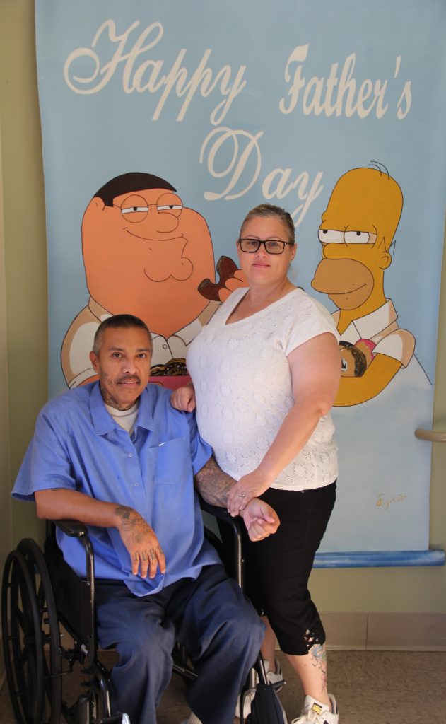 A man in a wheelchair and a woman at CHCF visiting.