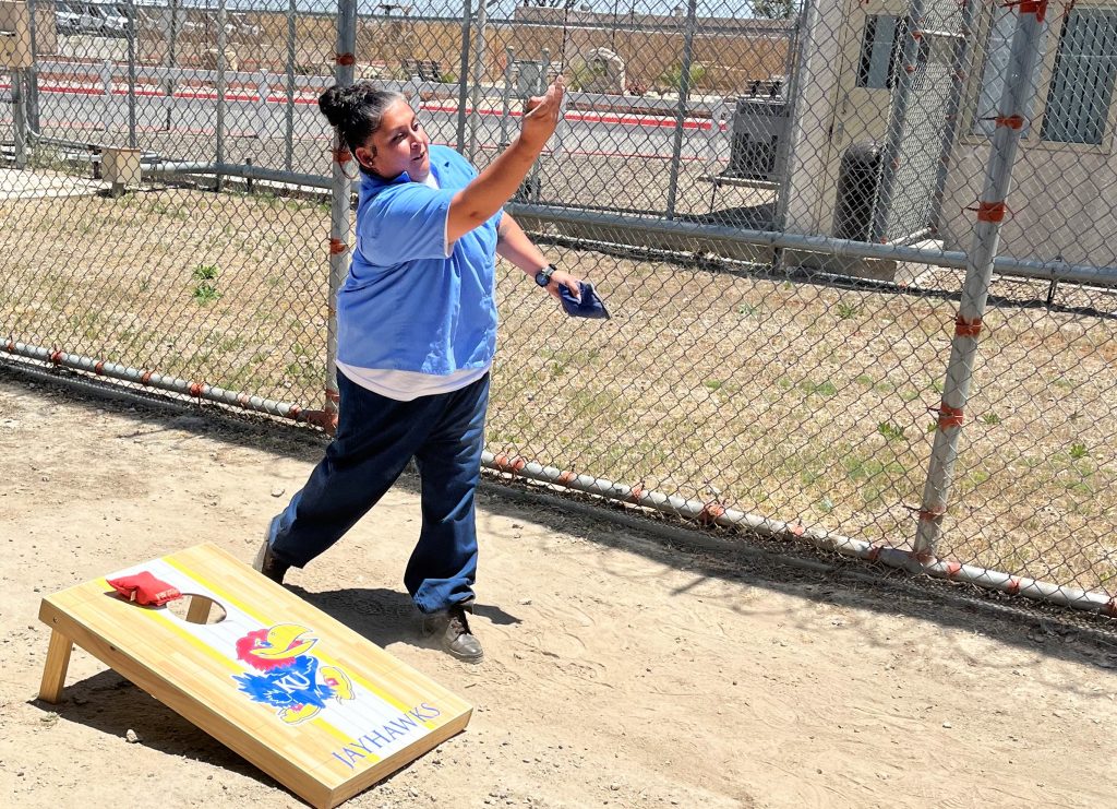 An incarcerated woman plays corn hole at California Institution for Women on Father's Day.