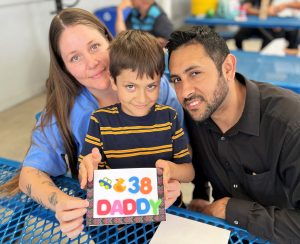 A family makes a Father's Day card during prison visiting.